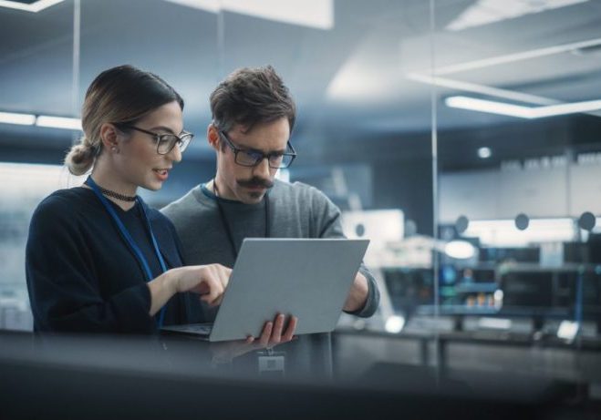 Business professionals reviewing technology data on a laptop